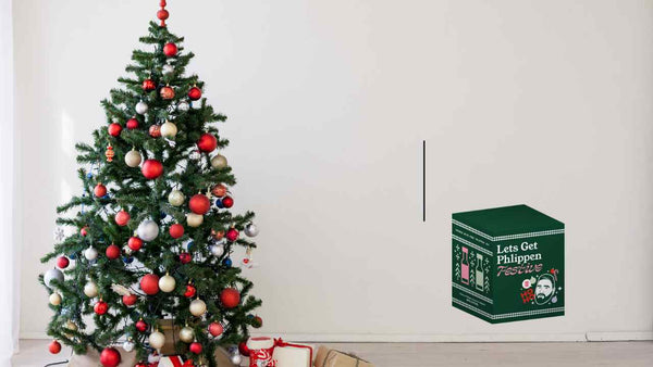 Decorated Christmas tree with a box labeled 'Let's Get Phlegm' on a white background