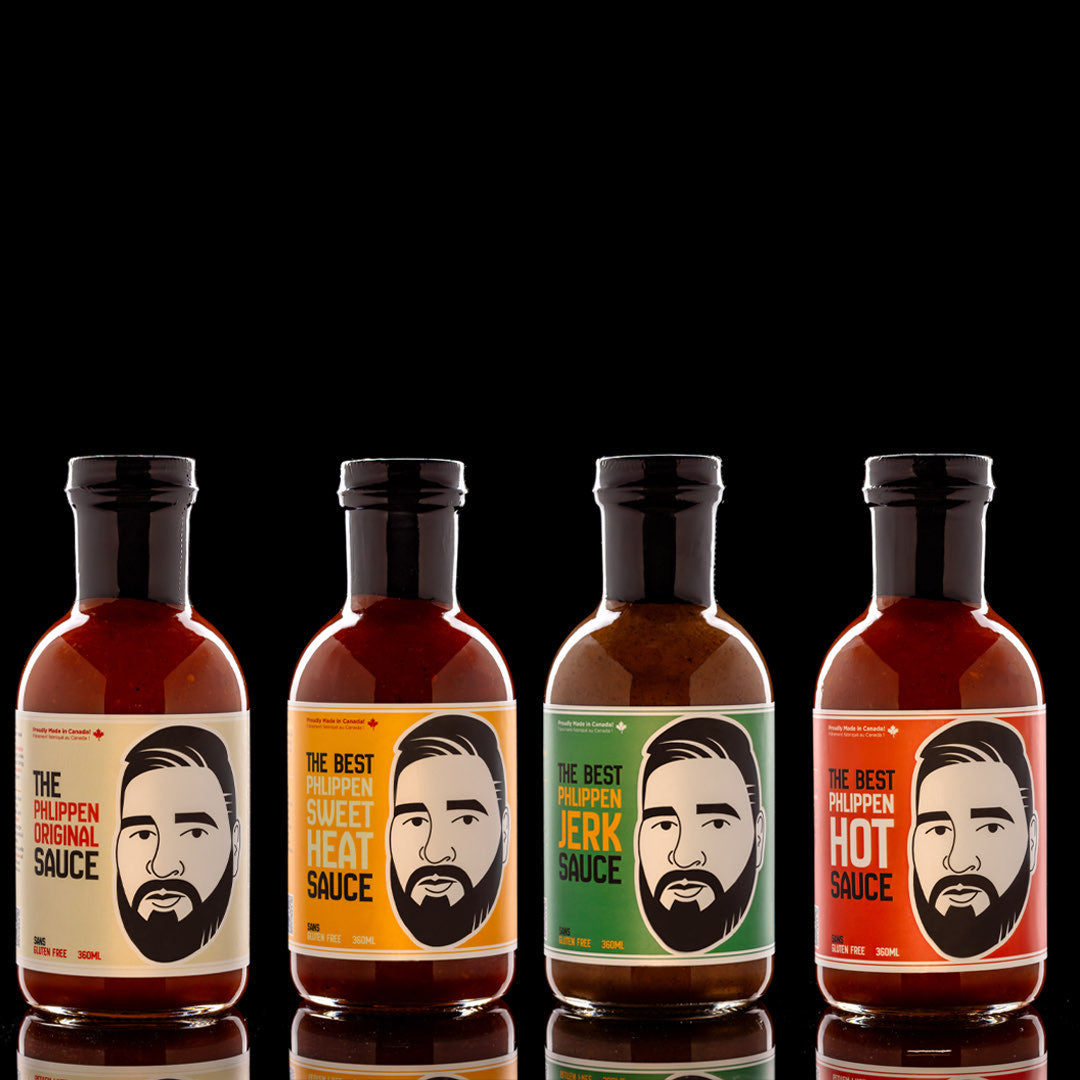 A collection of four bottles of Phlippen's sauces, featuring labels indicating four different flavors: Original Smoked Sauce, Hot Smoked Sauce, Sweet Heat Sauce, and Jerk Sauce.