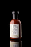Single back of the bottle of Phlippen Original sauce, made in small batches with hand-smoked local ingredients for a complex flavor, perfect for pizza and meats.